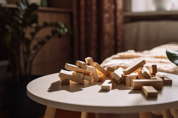 Disassembled wooden blocks from the game Jenga lie on a white table.