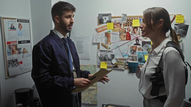 A man and woman detective analyze clues on a board in a police department's investigation room.