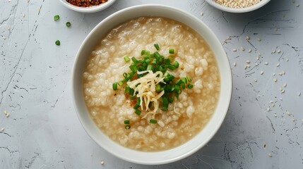 Top view culinary advertisement of Congee, a comforting bowl of Chinese rice porridge with rich, savory toppings, against a clean isolated background