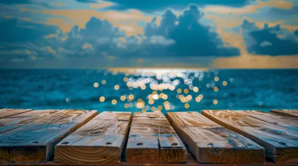  Golden sunset over the ocean viewed from a rustic wooden pier perspective. © tashechka