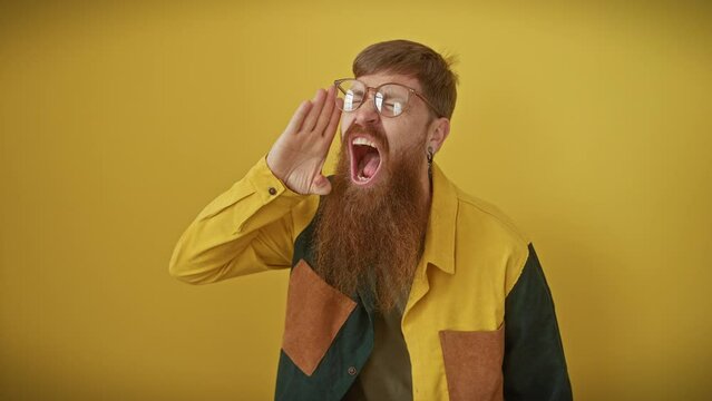 Furious redhead guy lets loose a thunderous shout! young stressed man in glasses yelling loudly, hand amplifying his angry message on a bright yellow backdrop