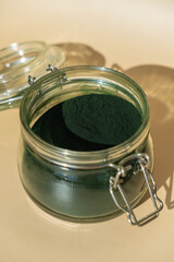 Organic blue-green algae spirulina powder food in glass jar. Health benefits of spirulina chlorella. Dietary supplement superfood