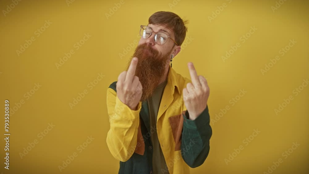 Canvas Prints Cheeky young redhead guy in glasses and shirt, flashing a crude 'fuck off' sign, showing you his naughty, impolite attitude with a bad boy smirk over isolated yellow background.