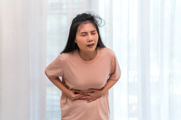 Woman sick unhappy holding belly stomach with suffering from stomach ache pain, monthly period,...