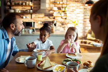 Young mixed family eating together at home