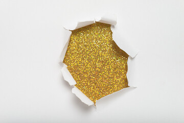 White paper with torn hole in the center revealing gold background with glitter. Space for text.