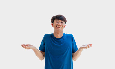 A young Asian man in his 20s wearing a blue t-shirt acts in a relaxed manner isolated on a gray background. A carefree man. concept of positivity