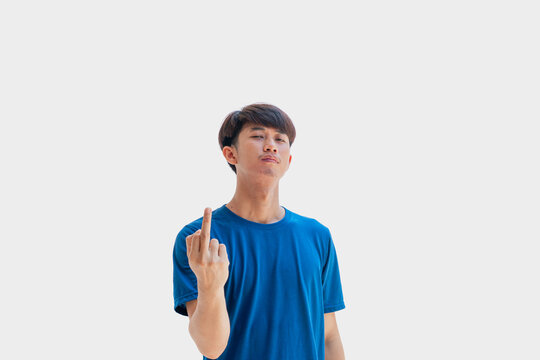 A young Asian man in his 20s wearing a blue t-shirt makes a gesture of showing your middle finger and scolding Fuck You isolated on a gray background