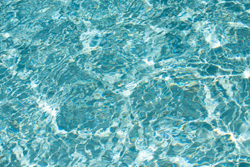 Blue pool water background. Blurred transparent clear calm water surface texture. Water waves in...