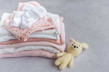 Stack of Baby bodysuits  on a grey background.