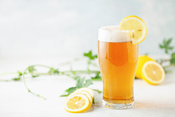 Boozy Refresing Cold Lemon Beer or Radler in a Pint Glass  on the table.