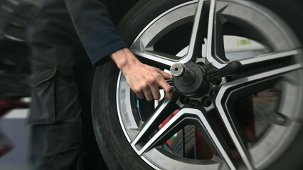Technician work car service. Auto mechanic balancing big wheel. 30s man change tyre cover job. Guy...