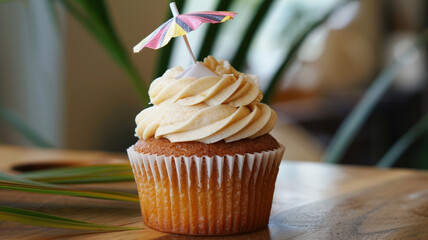 A cupcake with creamy coconut frosting and a tiny, edible paper umbrella on top, invoking the spirit of a tropical birthday getaway.