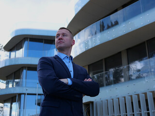 Businessman adopts a confident posture, hands crossed at chest. Businessman displays a calm,...