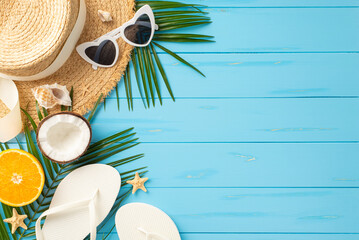 A vibrant collection of summer beach items like sunglasses, hat, flip flops, coconut, and orange on a turquoise wooden surface depicts the ideal vacation vibe - obrazy, fototapety, plakaty
