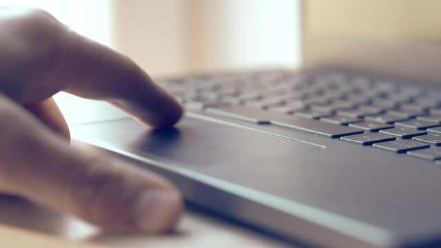 Finger pressing trackpad on modern laptop computer
