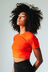 Young Woman in Orange Crop Top Posing Against a Neutral Background - 793598079
