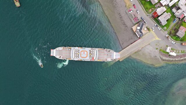 Aerial Birds Eye View Of Ferry Boat Docked At Ramp In Hornopiren Town Located In Commune Of Hualaihué in Palena Province, Southern Chile. Rising Shot