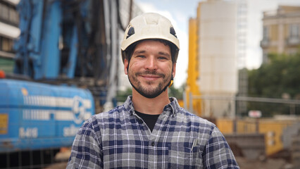 Confident construction site worker portrait. Smile constructor man look at camera. Builder engineer...