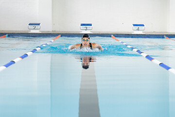 Biracial young female swimmer wearing goggles training in swimming pool, copy space - Powered by Adobe