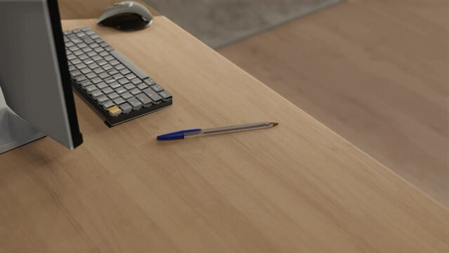 3D animation of a blue BIC pen on a home desk next to a computer