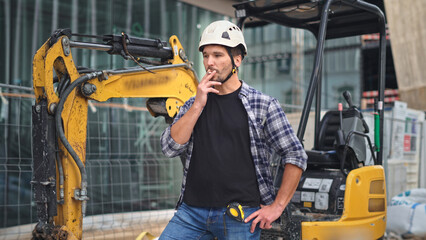 Confident construction site worker. Constructor man smoke cigarette. Builder engineer wear white helmet. Excavator driver plaid shirt. Guy build new house city street. Erector job. Smoker take break.
