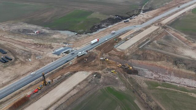 Drone shot of the road under construction for the expansion project, there is a huge construction site with the equipment for work.