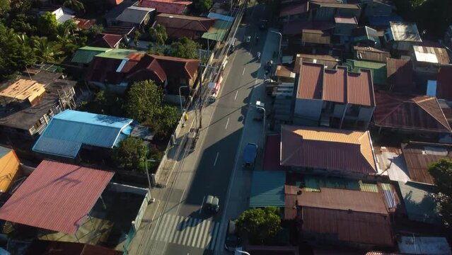 Cars driving on streets of San Pablo, Laguna, sunny evening in the Philippines - Aerial view