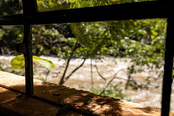metallic ruin window with blurred river in the background