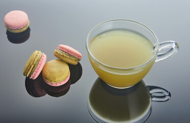 A colorful array of macarons encircle a steaming cup of coffee