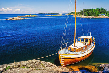 Moored wooden boat at a rock in the archipelago