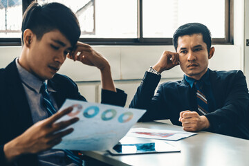 Unhappy business manager and young businessman partner in meeting room at the office. They are...