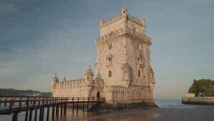 The Torre de Belem (Belem Tower) during sunrise is one of the symbols of the golden era of the Portuguese, Lisbon, Portugal