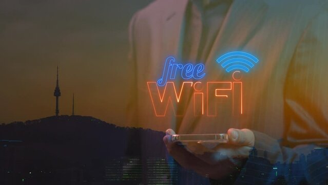 Wireless networking digital futuristic technology innovation concept. Businessman holding smartphone to show animation of Wifi wireless internet network symbol icon.