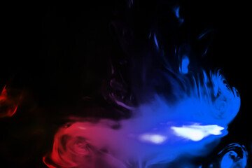 colorful smoke on dark background. Color steam on a black background. Red and blue smoke. Copy...