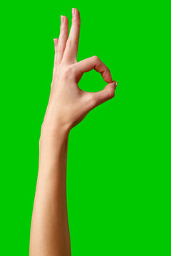 Hand Gesturing Okay Sign Against a Vibrant Green Background