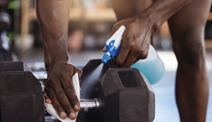 Gym, cleaning or man hands with sanitizer for dumbbell, safety or prevention of germs, virus and...