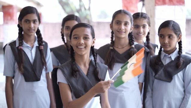 Group of proud rural government  schoolgirls students hold indian flag celebrating Independence day, Republic day, patriotism, education, people of india.