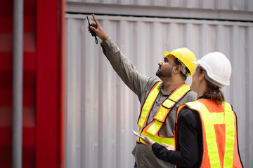 Middle east logistic worker foreman finger point with caucasian logistic worker pregnant woman at container site	