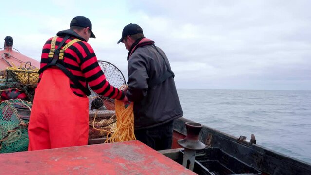Fishermen throw nets into the sea to catch lobsters