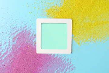 Empty  frame in yellow, blue, and purple textured background sprinkled with colorful sand. Ideal