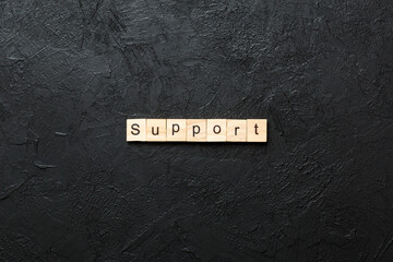 Support word written on wood block. Support text on cement table for your desing, concept