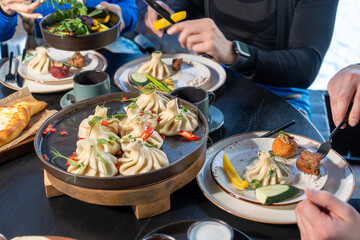 Delectable Georgian dumplings, Khinkali, garnished with vibrant red pepper. A feast for the senses,...