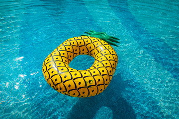 Yellow rubber ring floating in a blue pond on a summer day