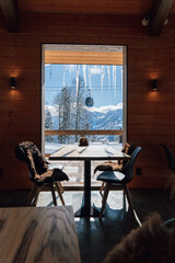 A cozy restaurant in a ski resort with a wooden interior with a panoramic window with stunning...