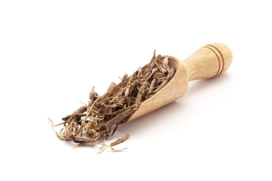 Top view of a wooden scoop filled with Organic Pellitory roots (Anacyclus pyrethrum). Isolated on a white background.