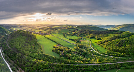 Aerial panoramic shot of Czech highlands during magical sunset with beautiful sky and green meadows...