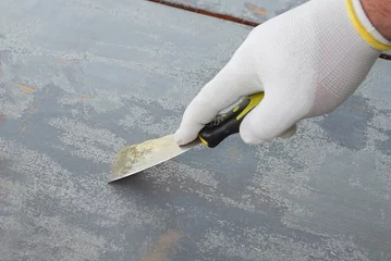 Fotobehang Removing paint from a wooden surface with a spatula after using a chemical product © KiNOVO