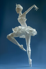 Dancing ballerina made of white origami isolated on blue background