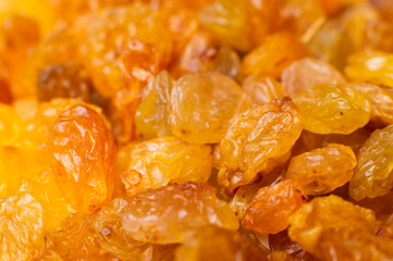 Background of a large number of dried yellow golden grapes. Raisin. Vegetarian diet